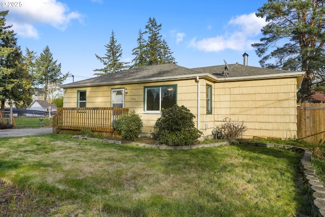 single story home with a deck and a front lawn