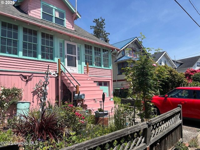659 Florence Ave, Astoria, OR 97103 - view of property exterior featuring stairway, a shingled roof, and a sunroom