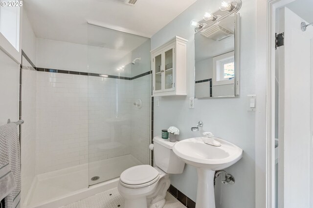 full bathroom with toilet, tile patterned floors, and a stall shower