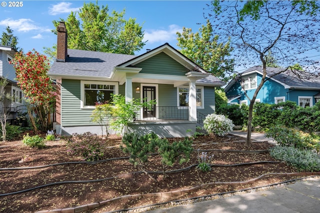 bungalow featuring a porch and a chimney