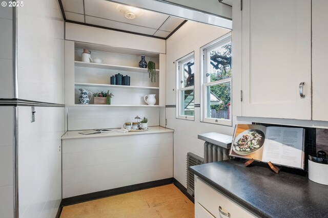 kitchen featuring open shelves, radiator heating unit, white cabinets, and dark countertops