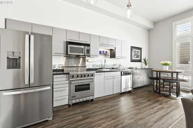 12600 SW Crescent St, Beaverton, OR 97005 - kitchen featuring stainless steel appliances, a sink, dark countertops, and dark wood-style floors