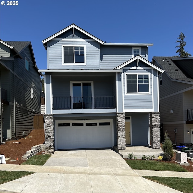 12176 SW Champlin Ln, Beaverton, OR 97007 - view of front of home with stone siding, concrete driveway, an attached garage, a balcony, and a porch