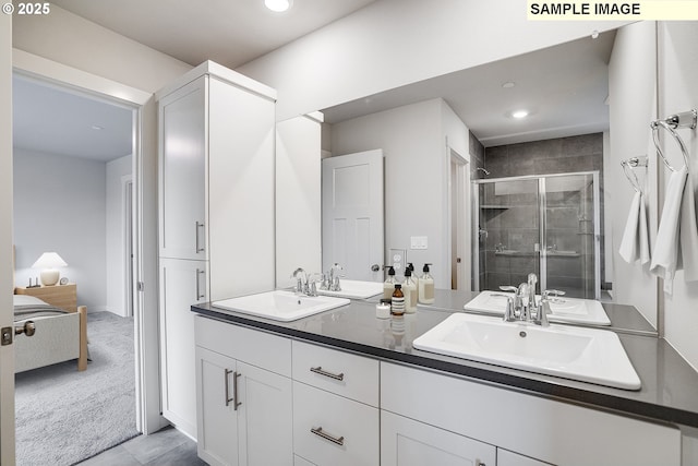 bathroom with recessed lighting, a sink, a stall shower, and double vanity