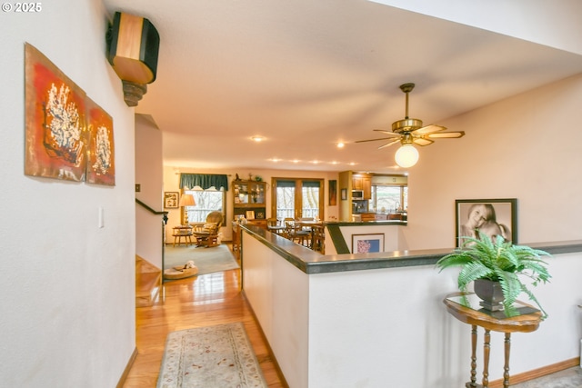 kitchen featuring kitchen peninsula, light hardwood / wood-style floors, and white cabinets