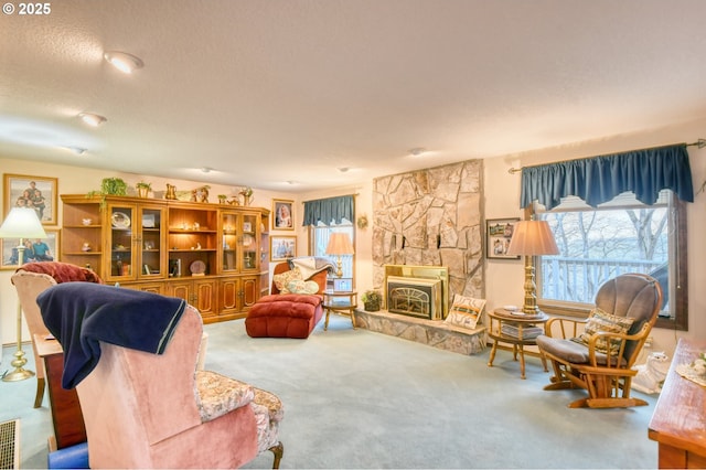 carpeted living room featuring a stone fireplace