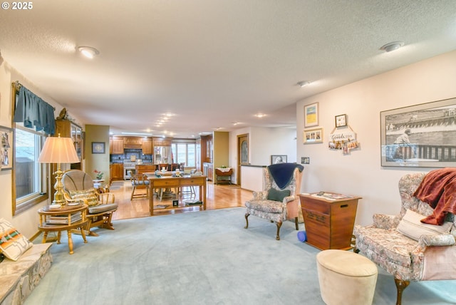 sitting room featuring light colored carpet and a textured ceiling