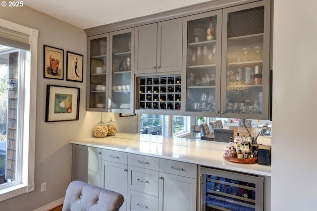 bar with wine cooler and gray cabinetry