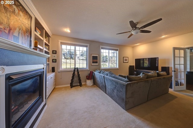 living room featuring a textured ceiling, ceiling fan, and light carpet