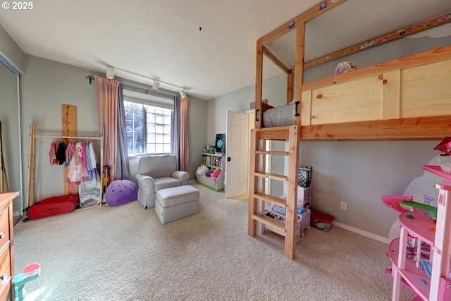 carpeted bedroom with rail lighting