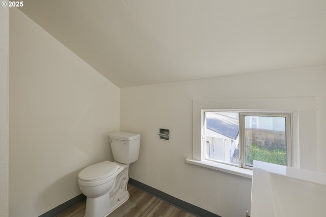 bathroom with hardwood / wood-style flooring, lofted ceiling, and toilet