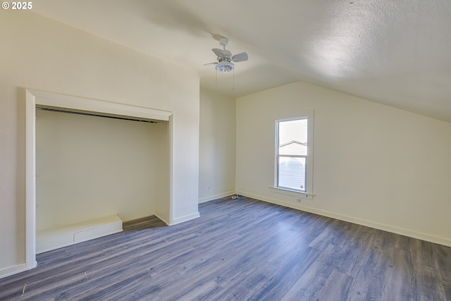 additional living space featuring ceiling fan, vaulted ceiling, dark hardwood / wood-style floors, and a textured ceiling