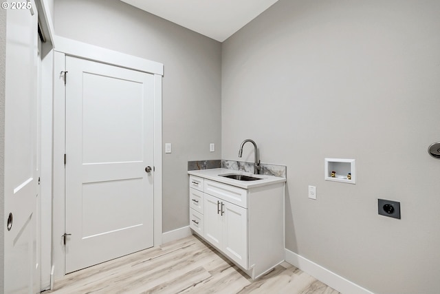 5477 SE Golden Rd, Hillsboro, OR 97123 - laundry room featuring a sink, hookup for an electric dryer, washer hookup, light wood-type flooring, and baseboards