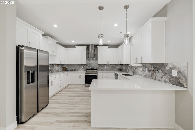 5477 SE Golden Rd, Hillsboro, OR 97123 - kitchen with appliances with stainless steel finishes, wall chimney exhaust hood, a peninsula, a sink, and light countertops