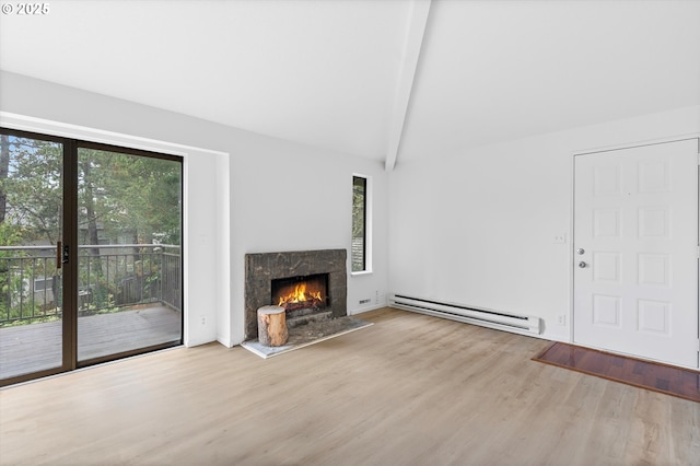 unfurnished living room featuring vaulted ceiling with beams, a wealth of natural light, a high end fireplace, and a baseboard heating unit