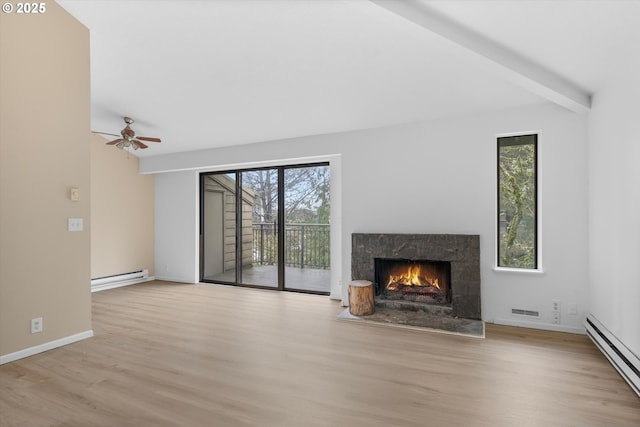 unfurnished living room featuring ceiling fan, light hardwood / wood-style floors, a premium fireplace, and a baseboard radiator