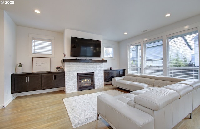 living area with plenty of natural light, light wood-style flooring, and recessed lighting