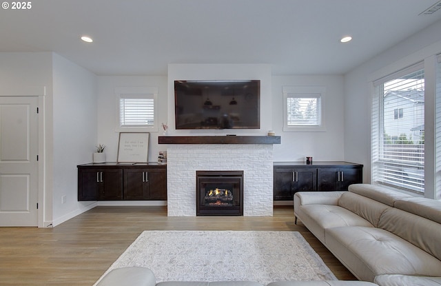 living area with recessed lighting, light wood-style floors, visible vents, and plenty of natural light