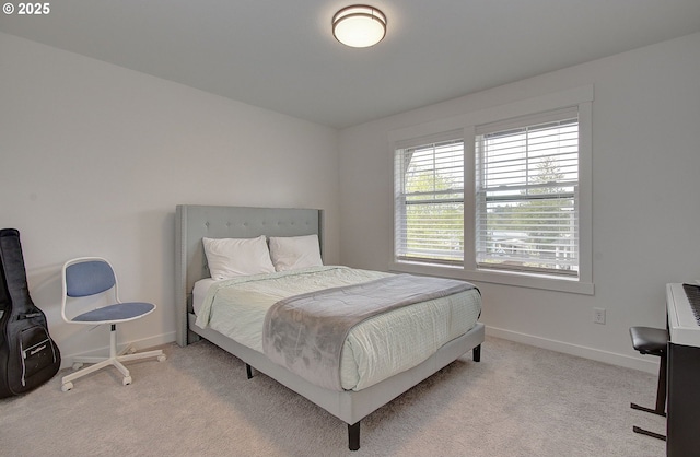 bedroom with light carpet and baseboards