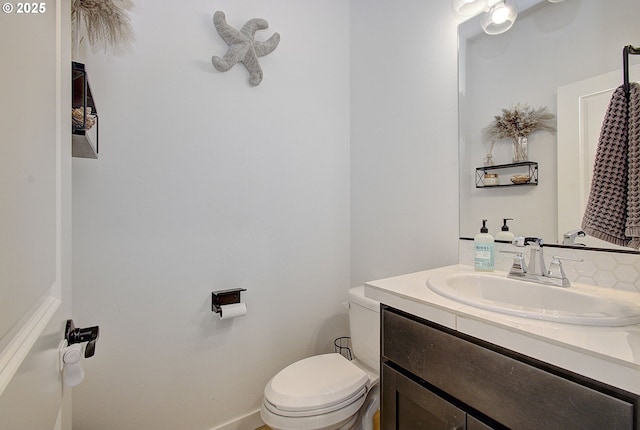 half bath featuring vanity and toilet