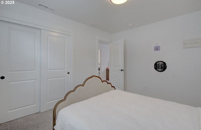 carpeted bedroom with visible vents and a closet