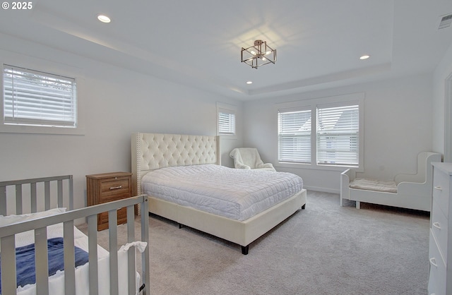 bedroom with recessed lighting, a raised ceiling, and carpet floors