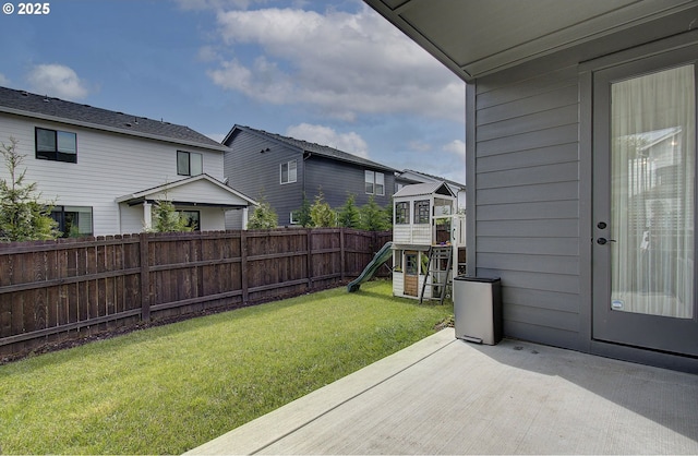 view of yard featuring fence, a patio, and a playground