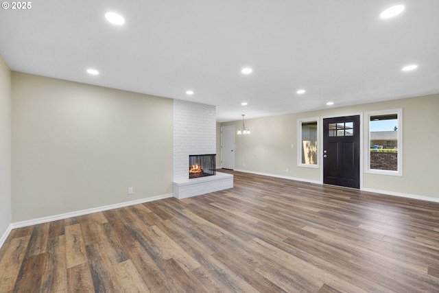 1080 Lockhaven Dr, Keizer, OR 97303 - unfurnished living room featuring a brick fireplace, wood finished floors, baseboards, and recessed lighting