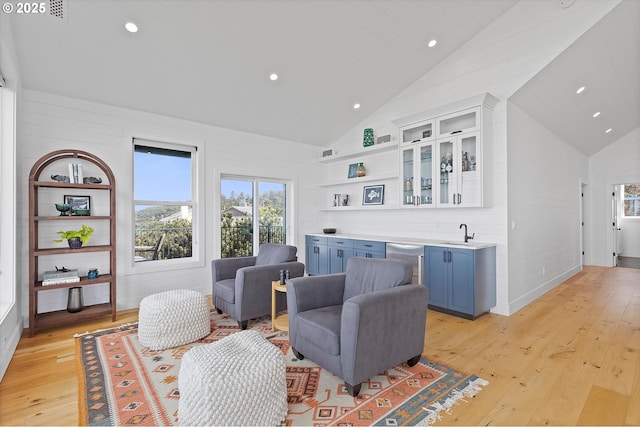 interior space with recessed lighting, high vaulted ceiling, light wood-type flooring, and indoor wet bar