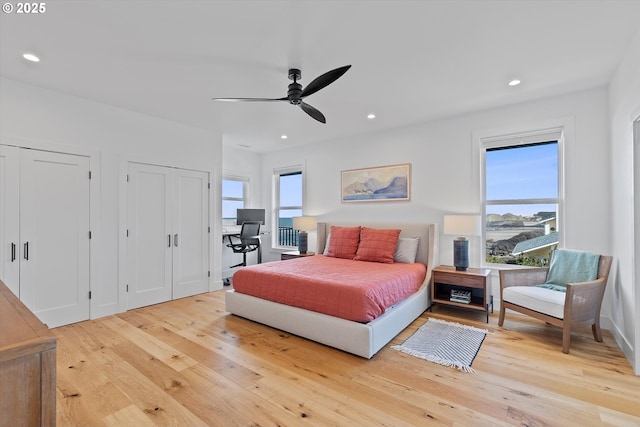bedroom featuring two closets, a ceiling fan, wood-type flooring, and recessed lighting