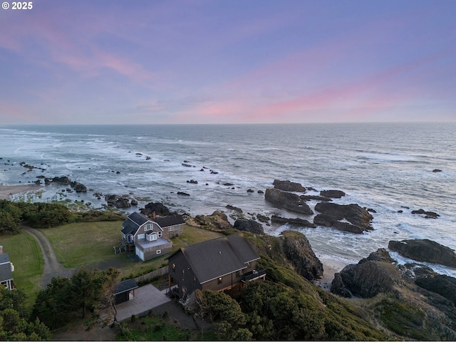 aerial view at dusk featuring a water view