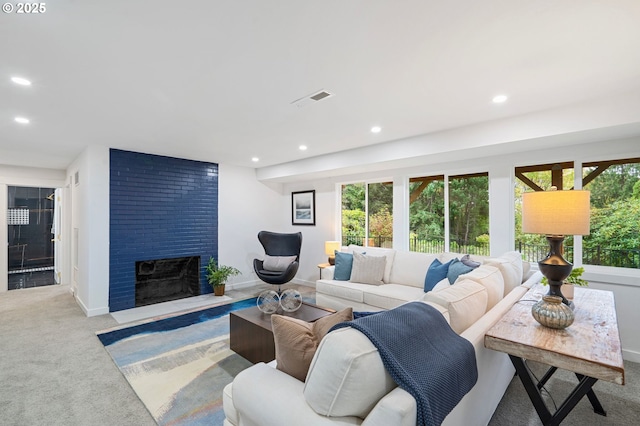 living room featuring a fireplace, a healthy amount of sunlight, and carpet