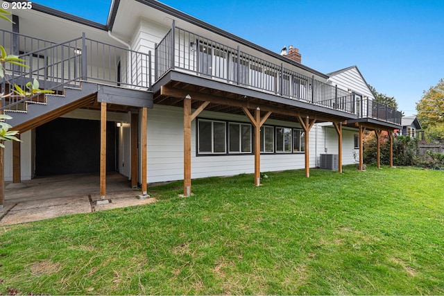 rear view of property with central AC unit, a yard, and a patio area