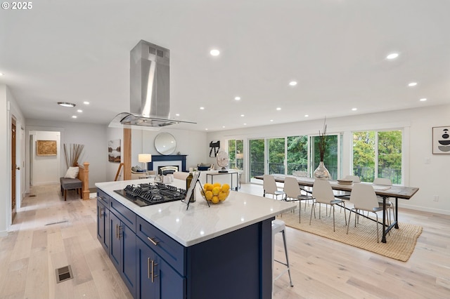 kitchen with light hardwood / wood-style flooring, island range hood, gas cooktop, and a kitchen island