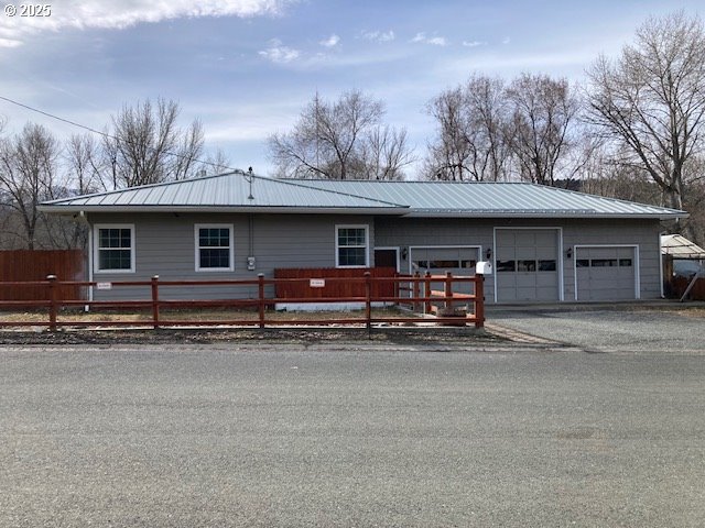 100 NW 7th Ave, John Day, OR 97845 - ranch-style house with metal roof and an attached garage