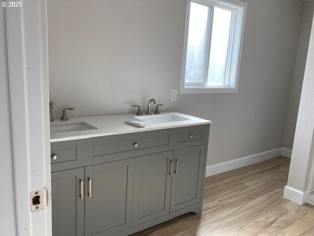 100 NW 7th Ave, John Day, OR 97845 - bathroom with baseboards, wood finished floors, and double vanity