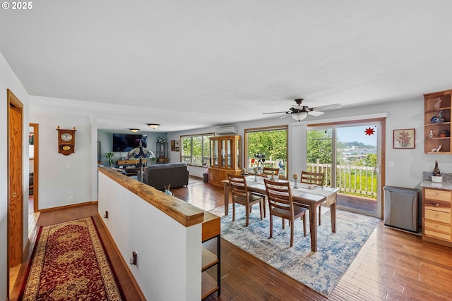 63642 Flanagan Rd, Coos Bay, OR 97420 - kitchen featuring a wall unit AC, wood finished floors, ceiling fan, open shelves, and fridge