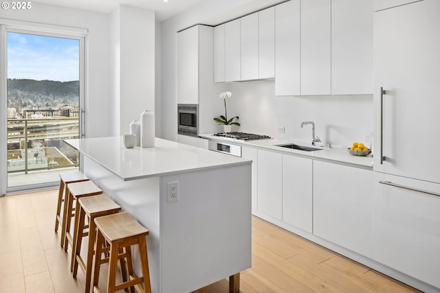 kitchen featuring light countertops, modern cabinets, a sink, and white cabinets