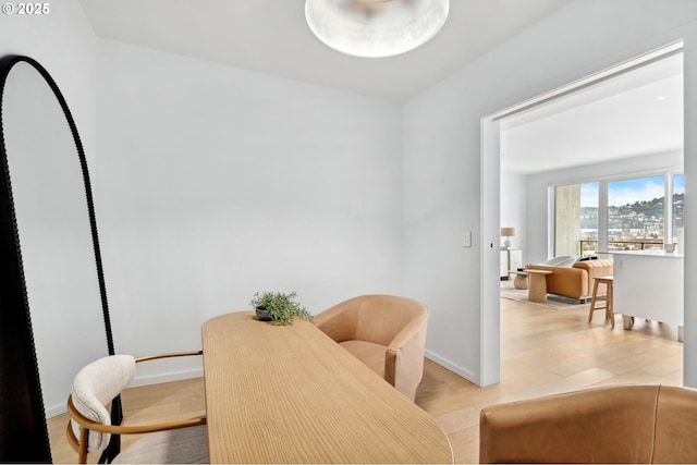 dining space featuring light wood-style flooring and baseboards