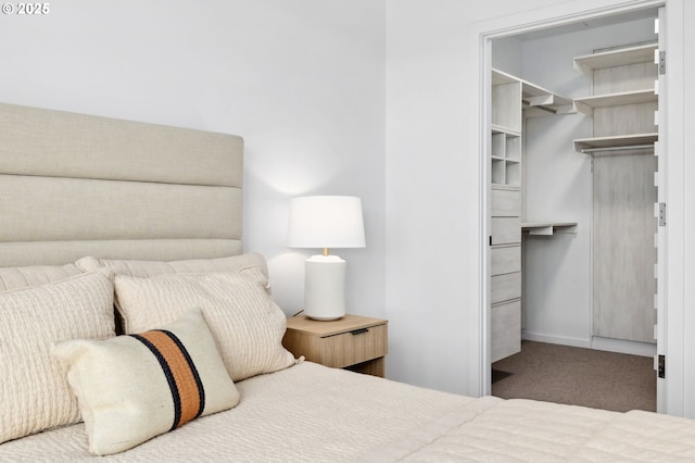 carpeted bedroom with a closet and a walk in closet