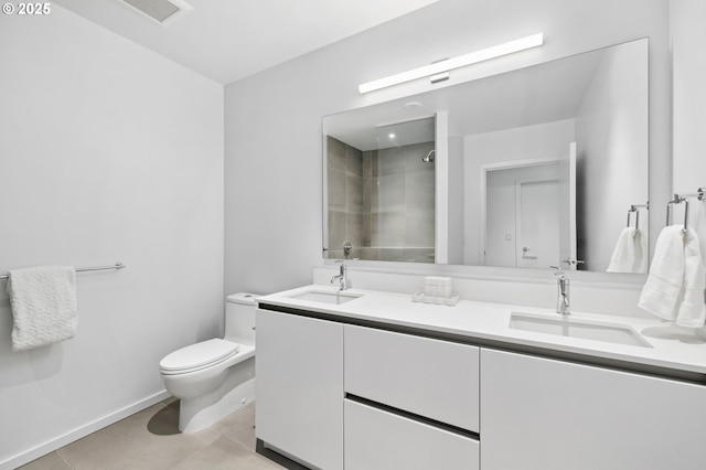 full bathroom with a sink, a tile shower, toilet, and double vanity