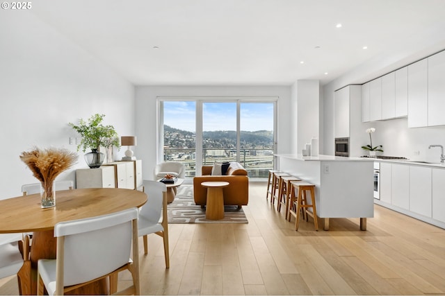 dining space featuring recessed lighting and light wood finished floors