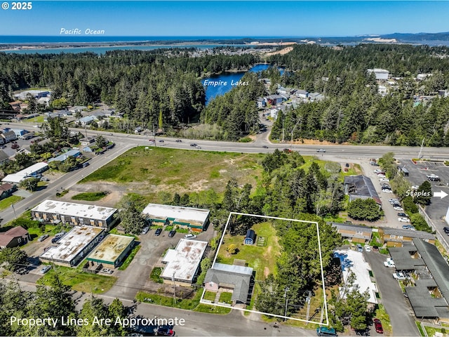 aerial view with a water view and a wooded view