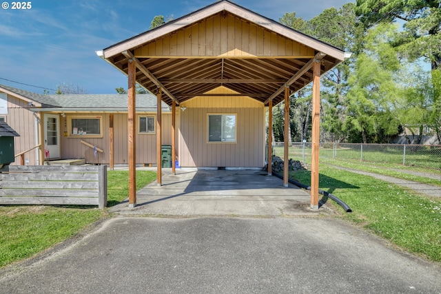 view of front of home featuring a shingled roof, fence, aphalt driveway, and a front lawn