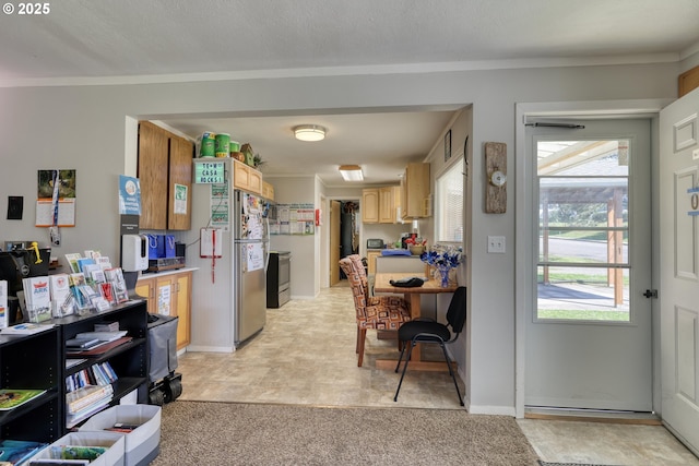 interior space with light brown cabinets, stainless steel appliances, light countertops, baseboards, and ornamental molding