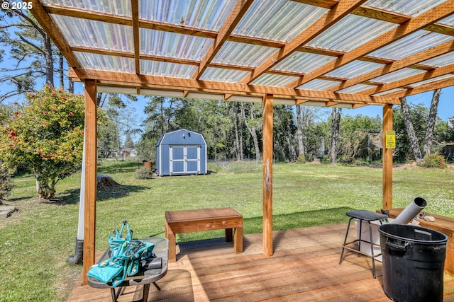 wooden terrace with a storage unit, a yard, and an outbuilding