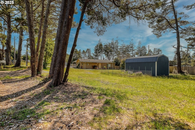 view of yard featuring fence and an outdoor structure