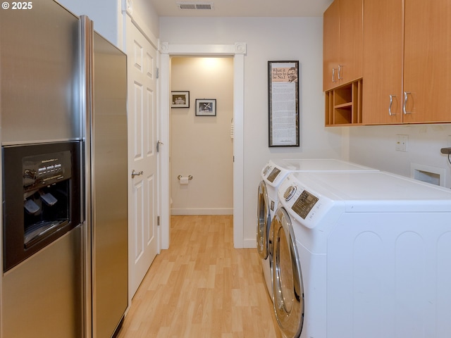 1802 NW Ogden St, Camas, WA 98607 - washroom with cabinet space, washing machine and clothes dryer, light wood-type flooring, and baseboards