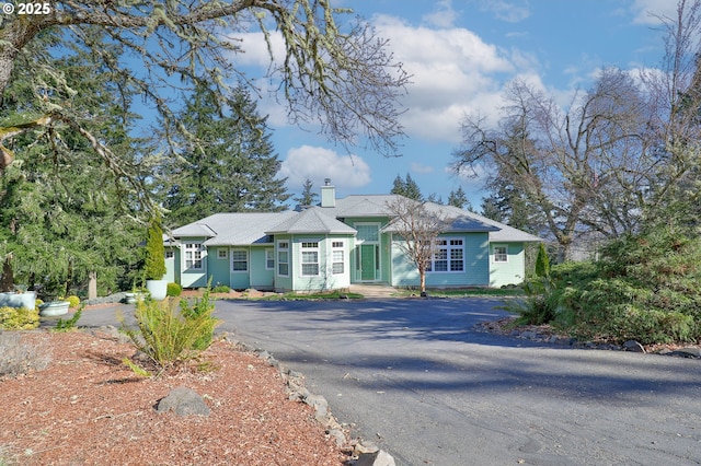 view of front of home with aphalt driveway and a chimney