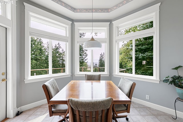 dining space featuring light tile patterned floors and baseboards